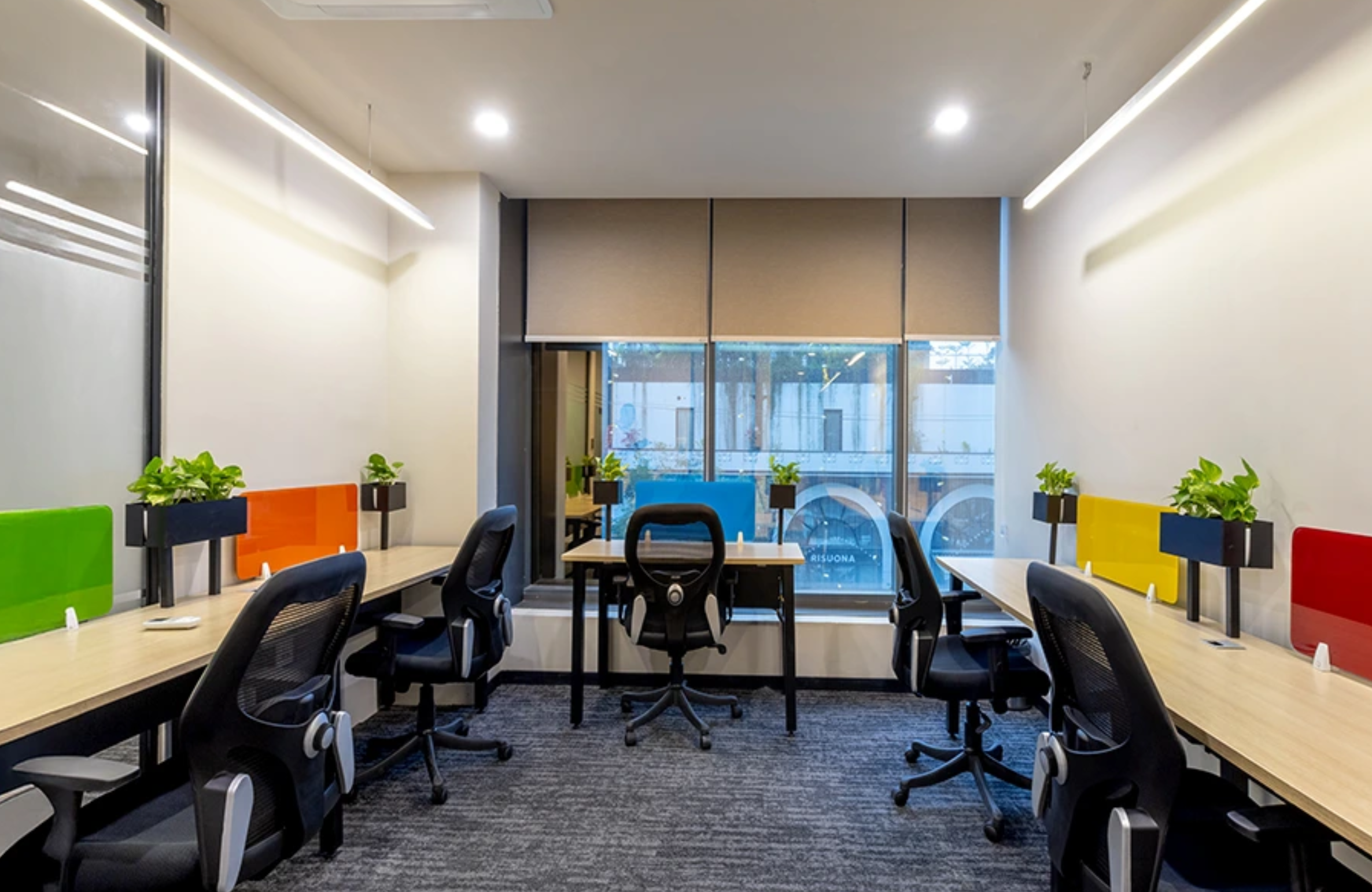 Bright Managed Office Space in Gachibowli for 15–25 Member Teams with dedicated workstations, ergonomic chairs, colorful desk partitions, natural lighting, and a modern office setup ideal for startups and growing businesses.